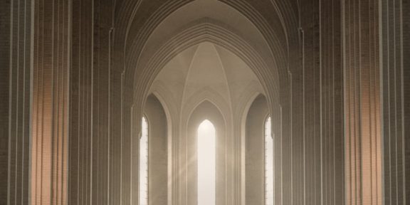 photo by daniele colucci man in black leather jacket standing inside building